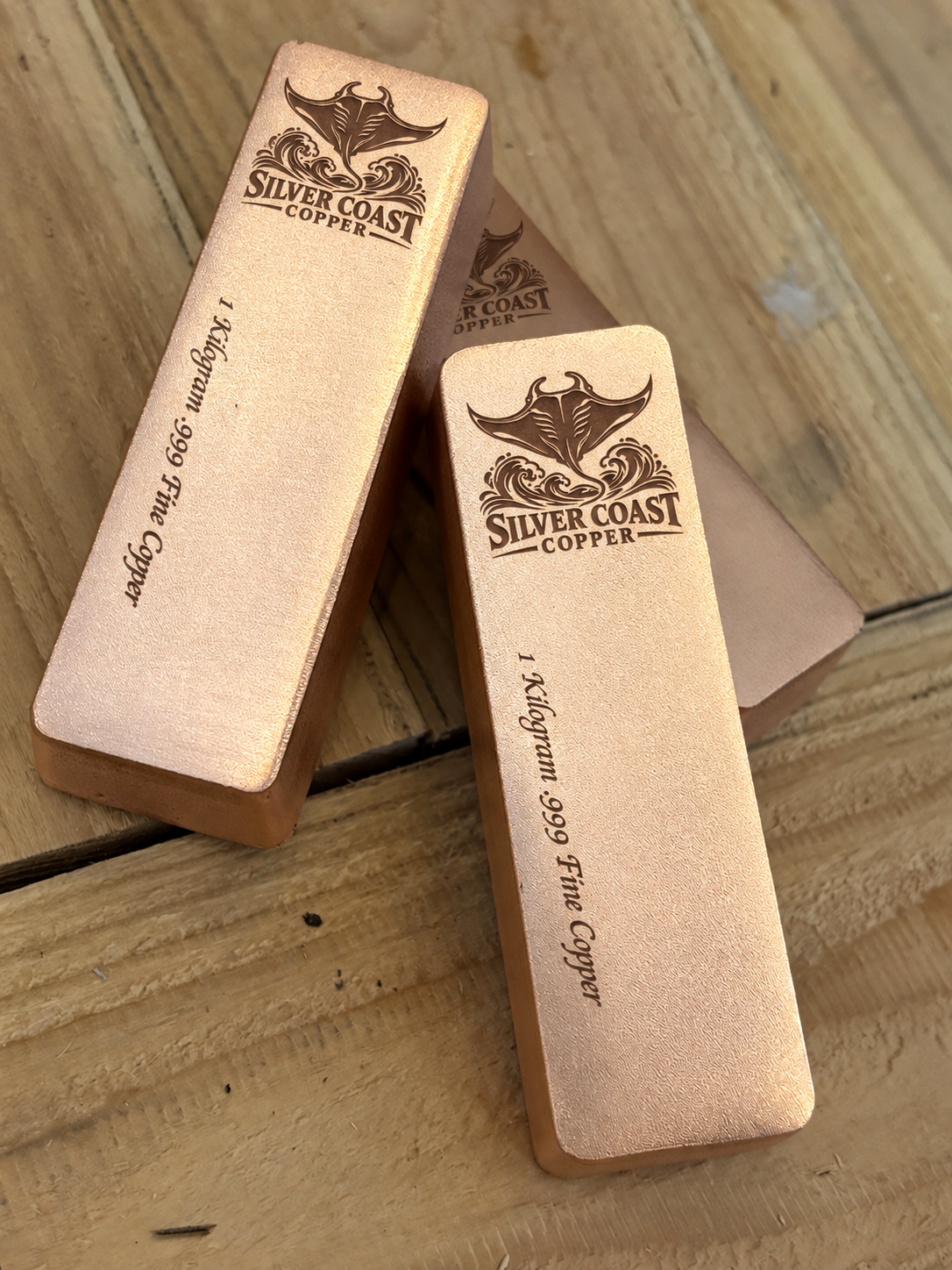 1 kilogram .999 fine copper manta ray logo bar in satin finish - close angled view of stacked bars