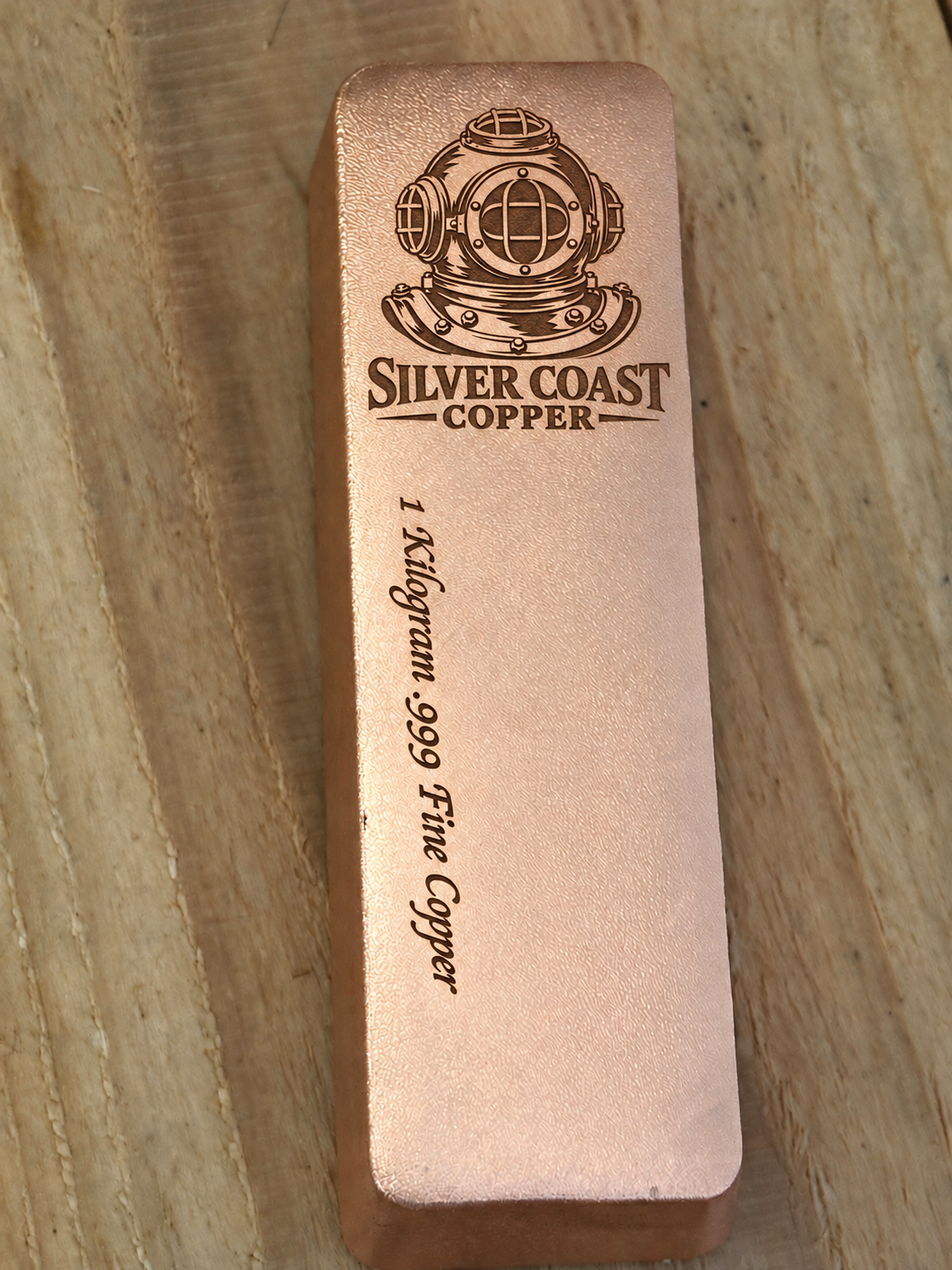1 kilogram .999 fine copper satin bar with Silver Coast Copper diver's helmet logo and lengthwise weight inscription, front view