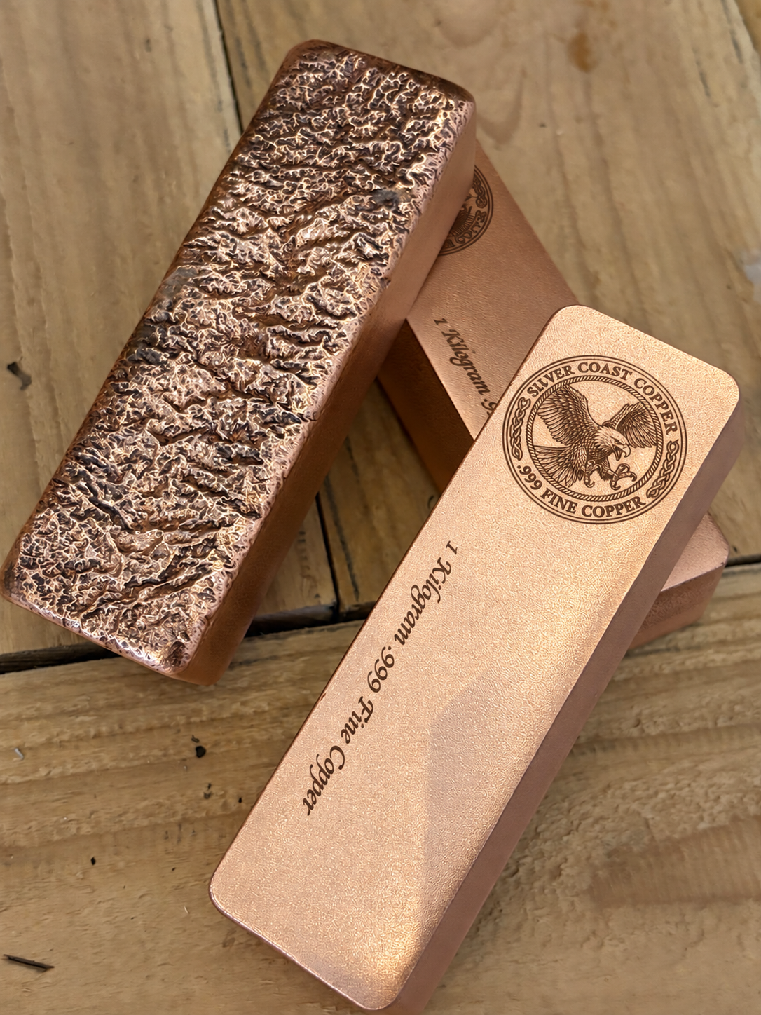 1 kilogram .999 fine copper eagle logo bar in satin finish - bar beside the rough cast reverse
