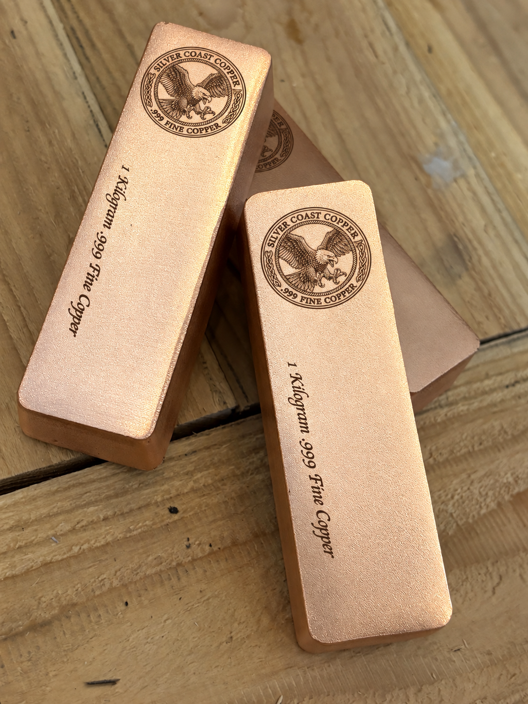 1 kilogram .999 fine copper eagle logo bar in satin finish - close angled view of stacked bars