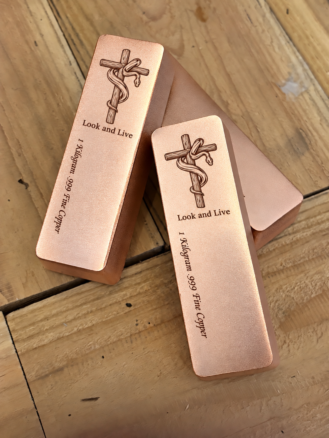 Look and Live 1 kilogram satin copper bar with engraved cross and serpent, stacked view