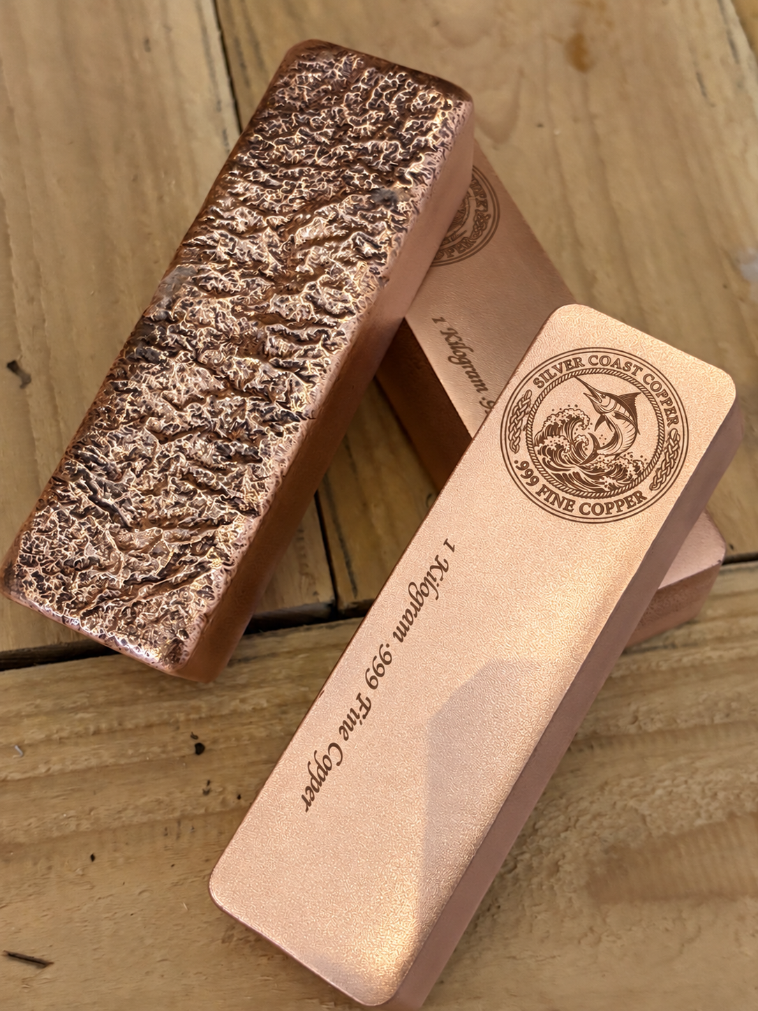 1 kilogram .999 fine copper marlin logo bar in satin finish - bar beside the rough cast reverse