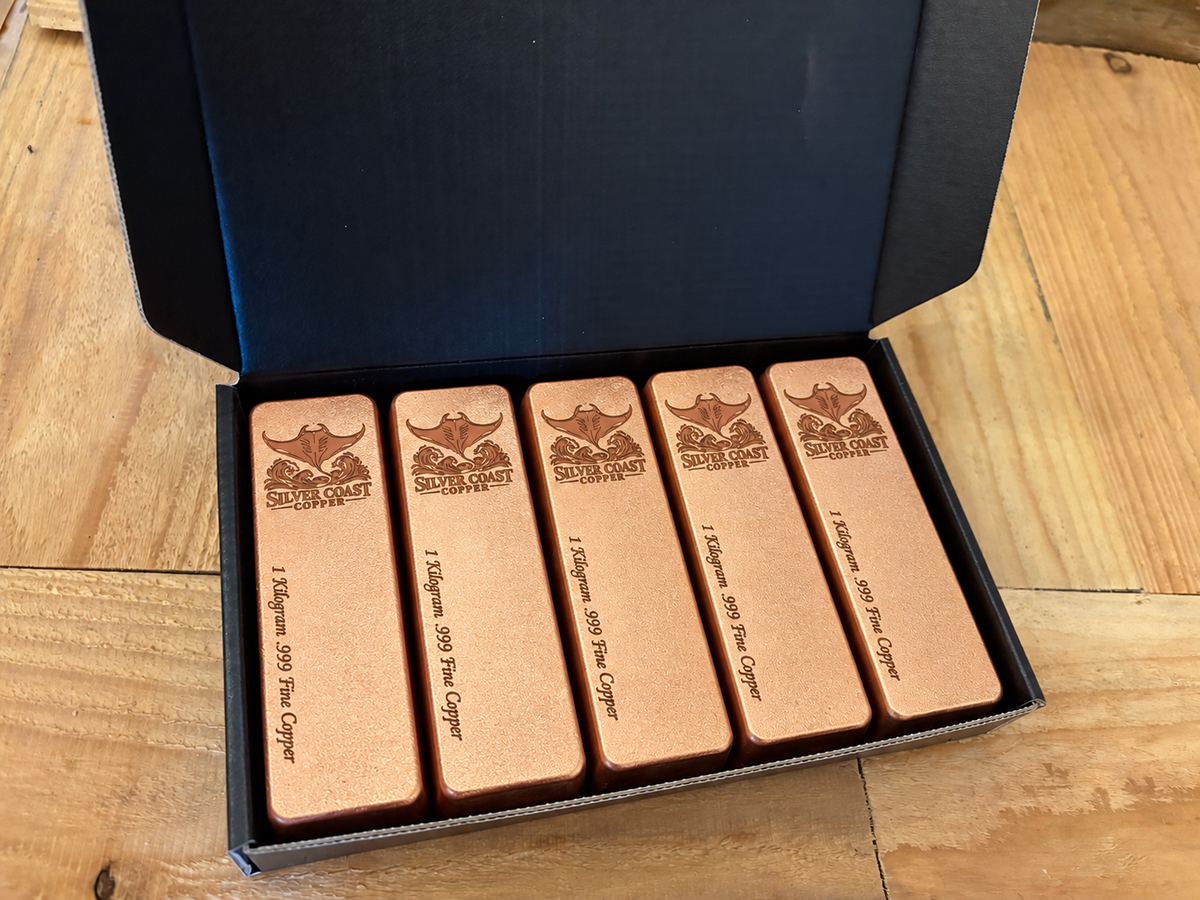 Manta Ray Logo five-pack: five 1 kilogram .999 fine copper bars in satin finish, displayed in an open black presentation box