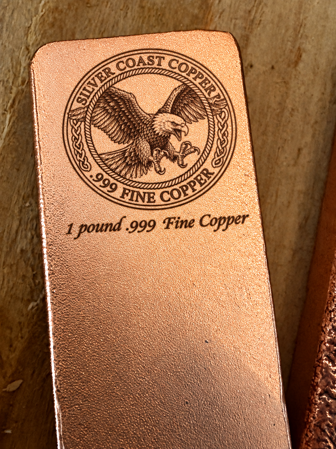 One pound .999 fine copper bar engraved with Silver Coast Copper eagle logo, close-up view
